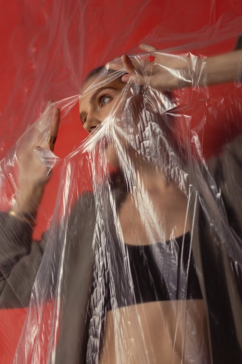 Woman in a Plastic Foil Making a Hole in it 
