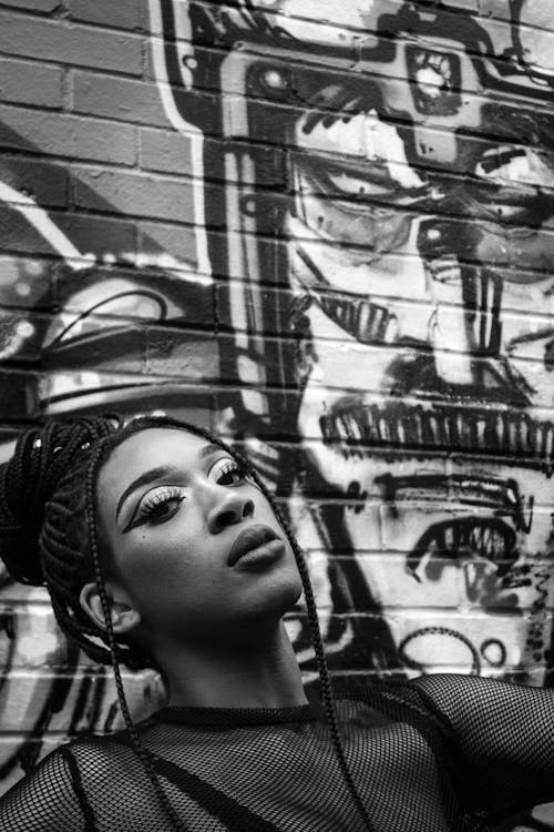 Grayscale Photography of Woman Leaning on Wall