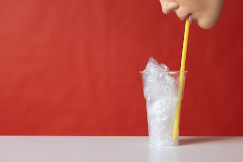 Free Clear Drinking Glass With Plastic and Yellow Straw Stock Photo
