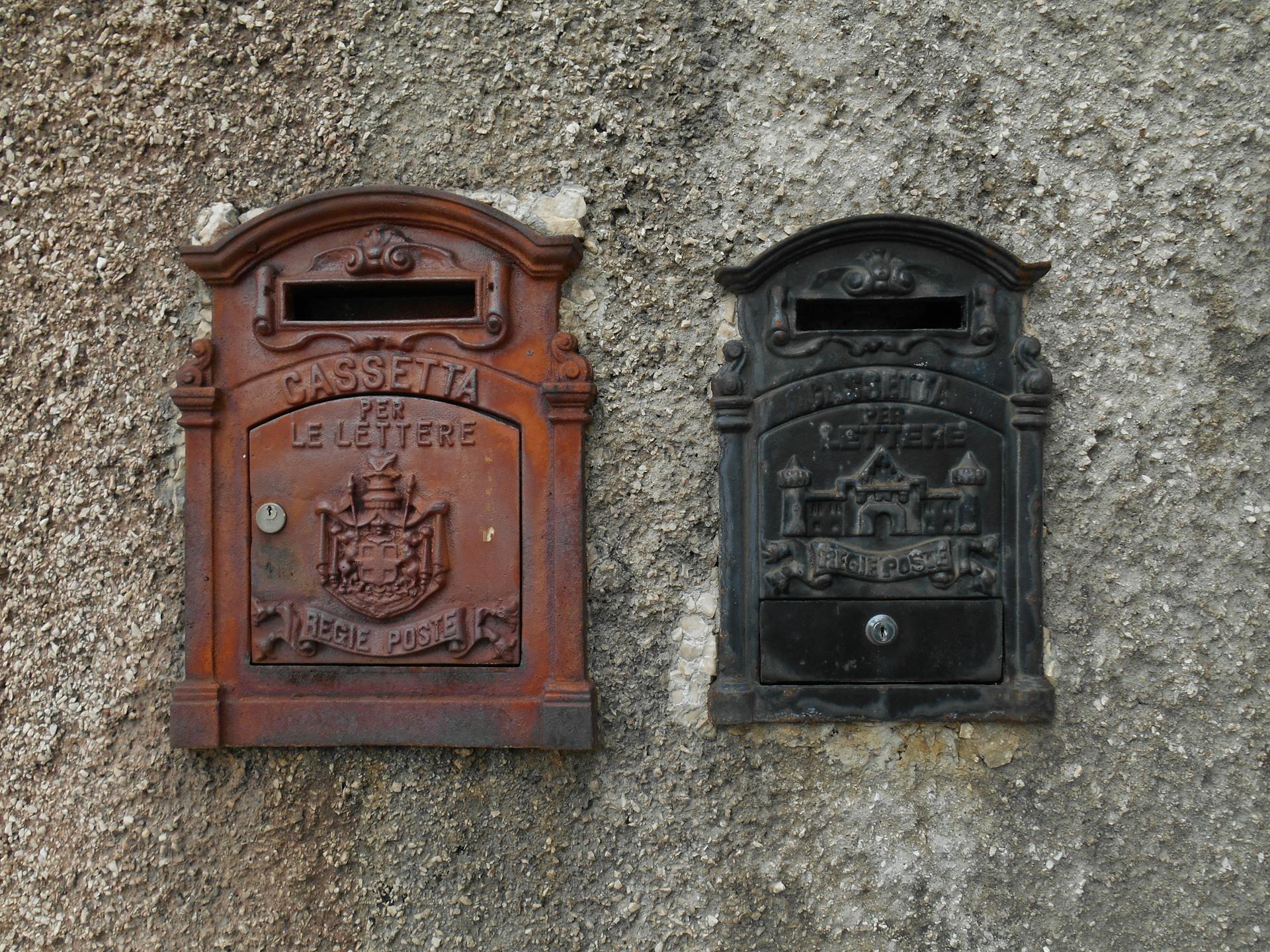 Red and Black Mail Box on a Concrete Wall