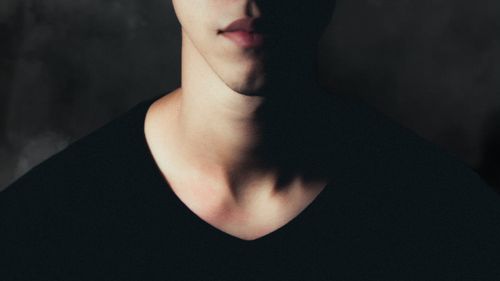 Free Dramatic close-up portrait of a young man with shadows on a grey background. Stock Photo