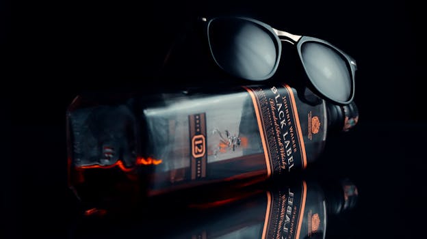 Whiskey bottle paired with sunglasses, highlighting a classic and elegant lifestyle.