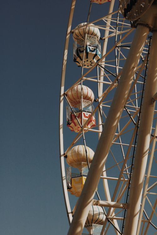 Free From below of modern metal observation wheel with colorful cabins against cloudless blue sky on sunny day Stock Photo