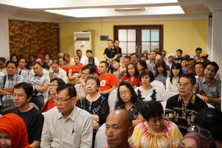 Group Of People Sitting In A Room