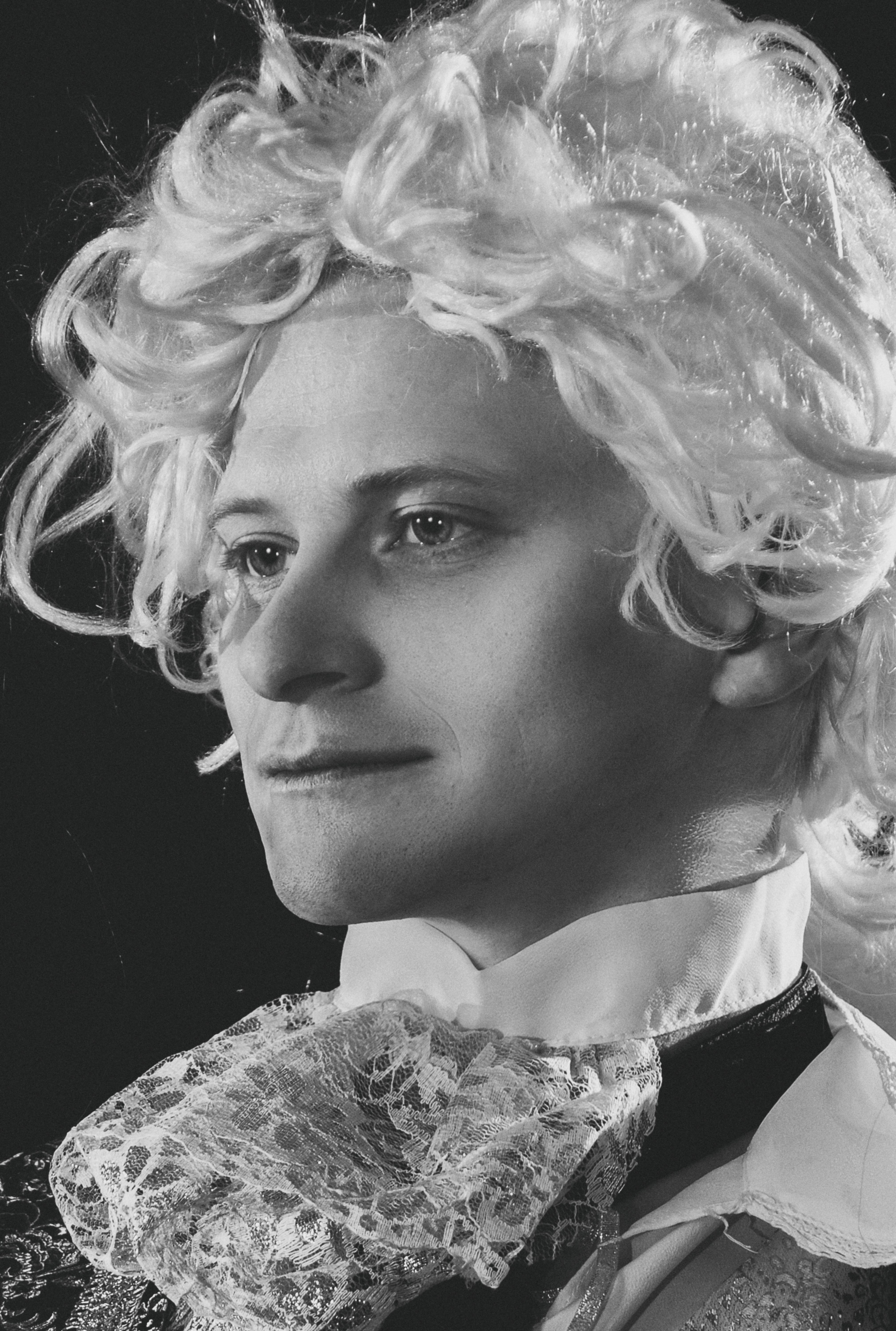 Artistic black-and-white portrait of a man in Baroque style attire, showcasing intricate costume details.