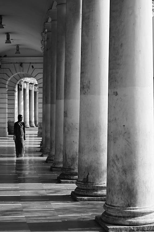 Free Grayscale Photo of a Person Walking on a Hallway Stock Photo