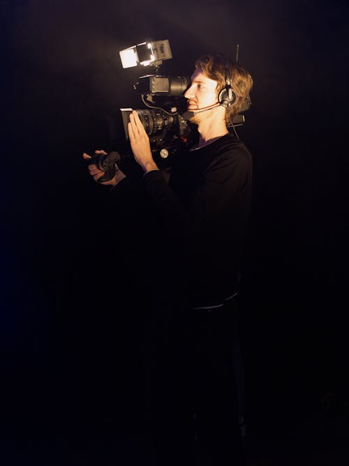 비디오 카메라를 사용하여 검은 색 긴팔 셔츠를 입은 남자