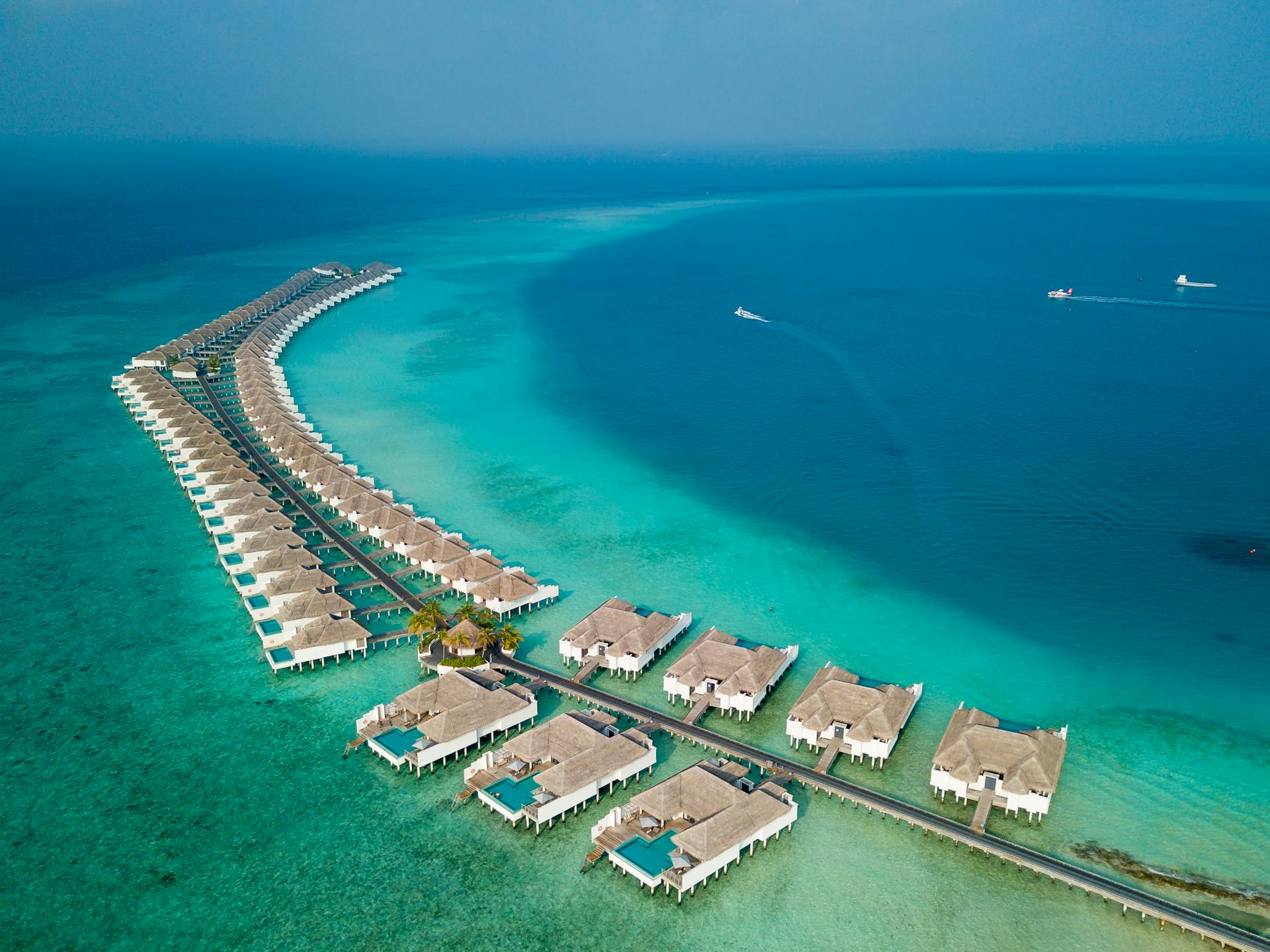 Stunning aerial view of luxury overwater villas and turquoise sea at Baa Atoll, Maldives.