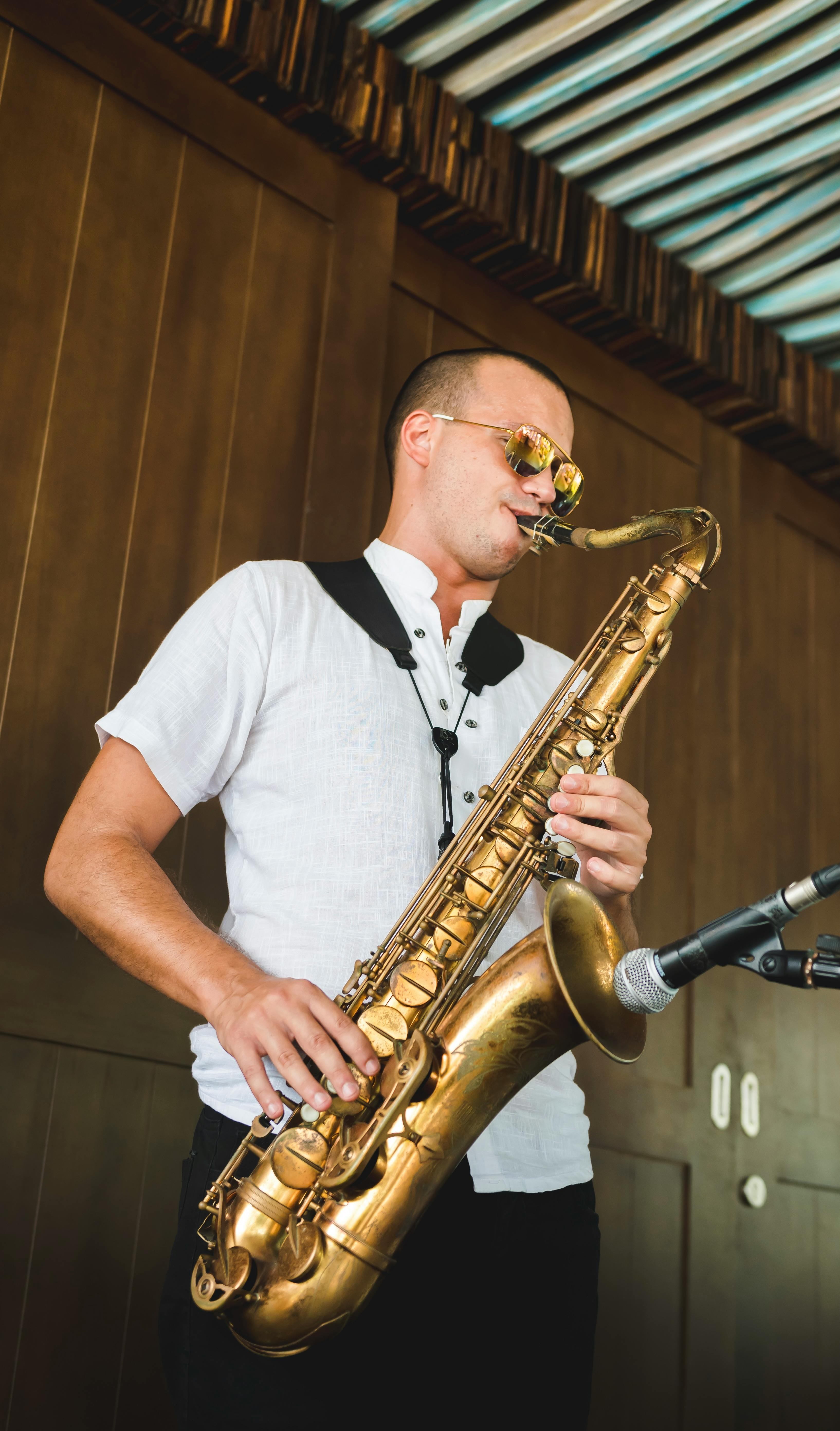 man playing saxophone in sunglasses