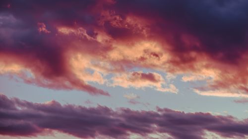 Free From below of picturesque sunrise with bright multicolored clouds floating in blue sky Stock Photo