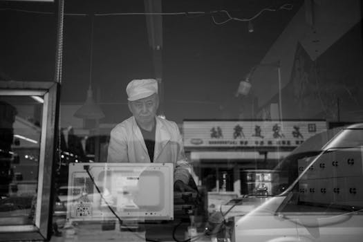 Monochrome portrait of a chef in a traditional Asian kitchen setting