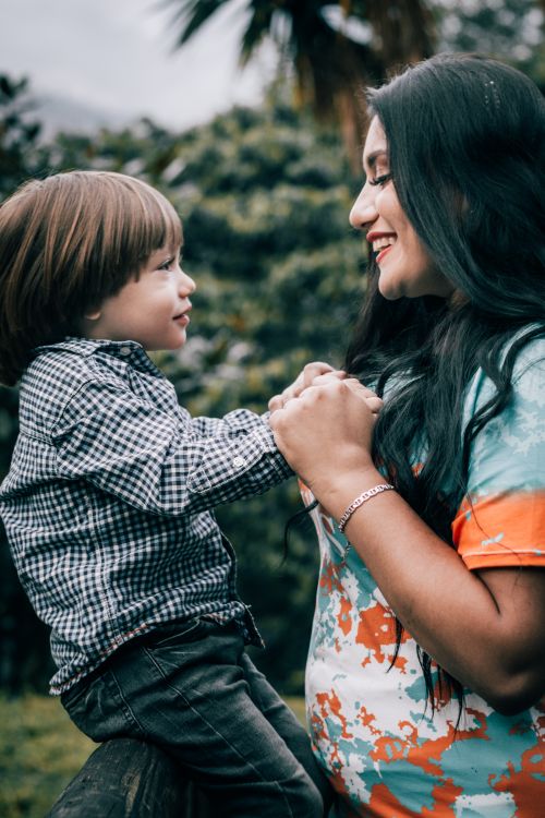 Free Smiling mother and son holding hands, sharing a moment in nature. Stock Photo