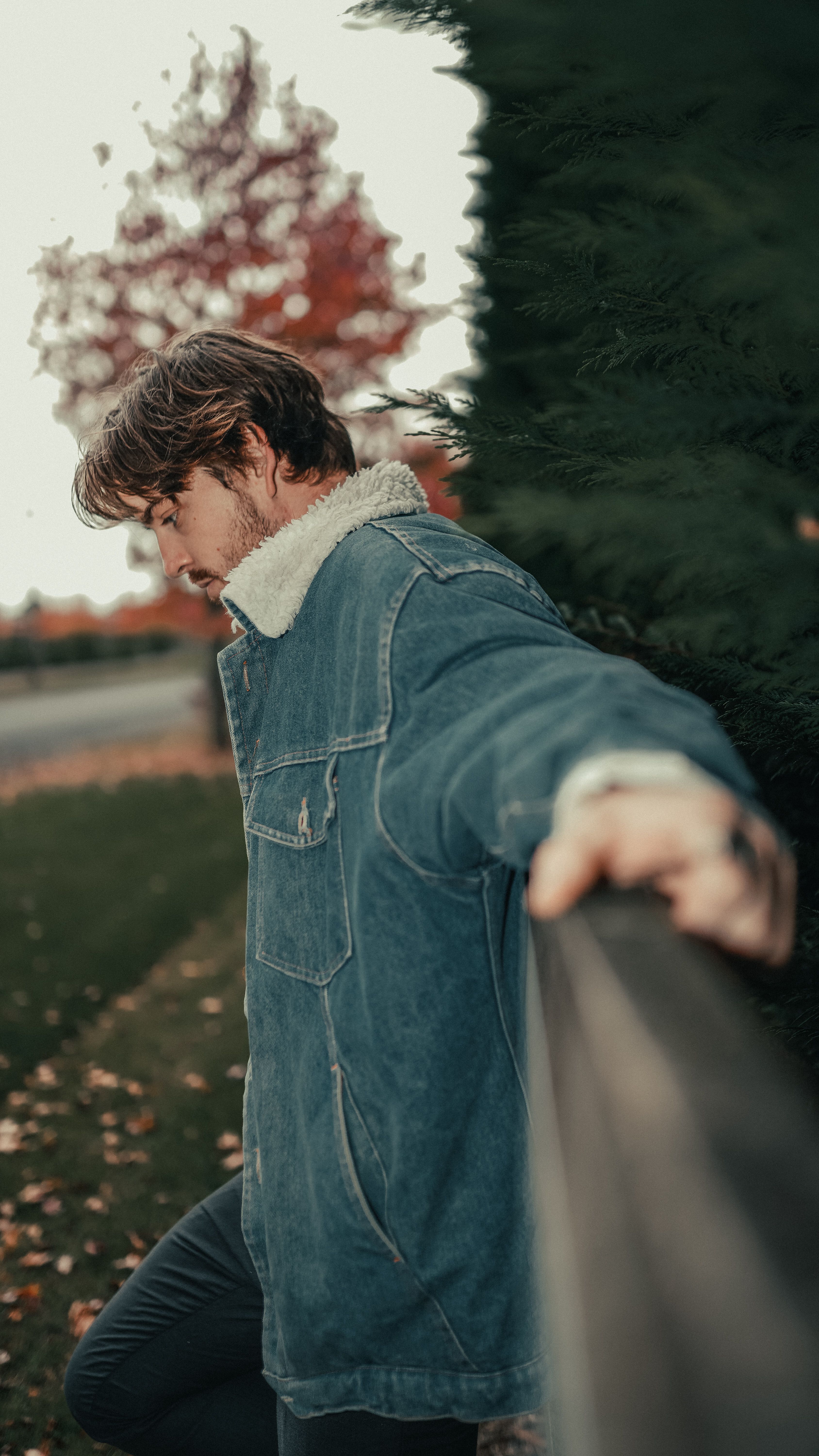 A Man in Denim Jacket Leaning on a Wooden Fence · Free Stock Photo