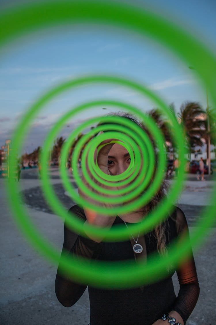 Woman Looking Through A Stretched Out Bouncy Spring Toy 