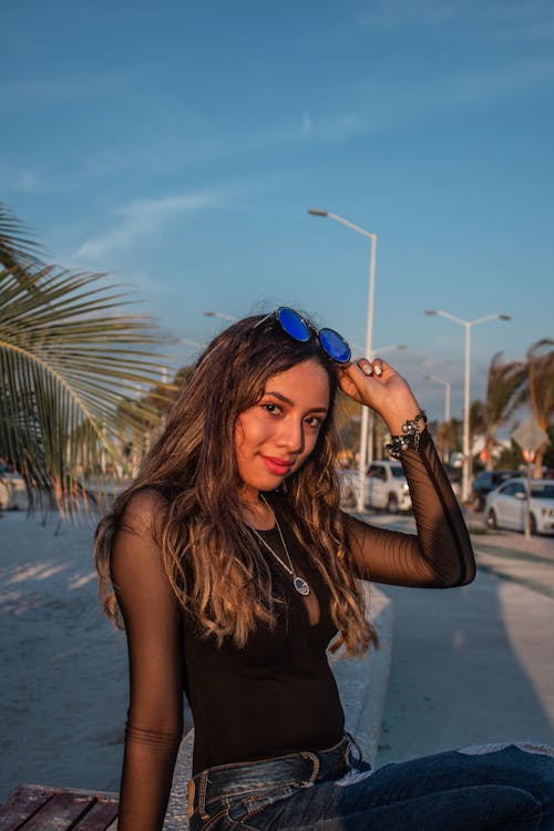 A Pretty Woman in Black Top Posing Outside