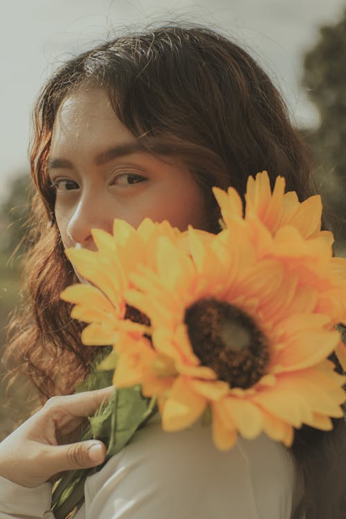 Close-Up Shot of a Woman Holding Sunflowers
