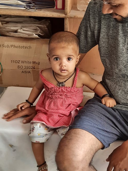 Photo of an Adorable Girl in a Pink Tank Top Looking at the Camera