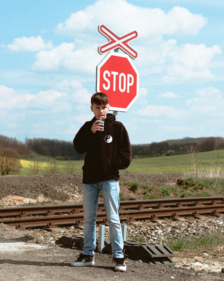 Man Standing By Rail Crossing