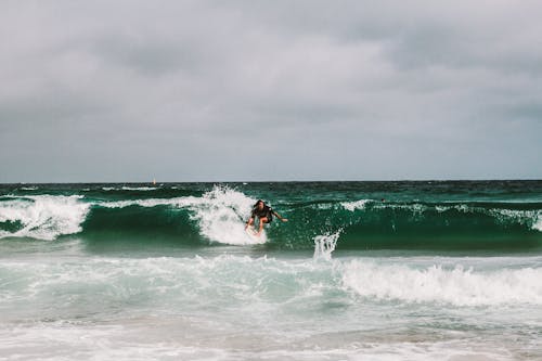 Free Man Surfing on Ocean Waves Stock Photo