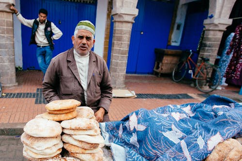 Free Photo of an Elderly Vendor Selling Fresh Bread Stock Photo