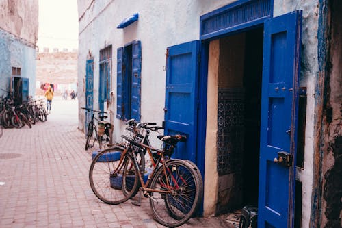 Brown City Bikes Parked Beside Blue Wooden Door