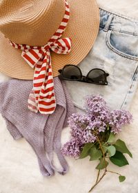 Straw hat, sunglasses and knitwear laid on denim — Melike B on Pexels