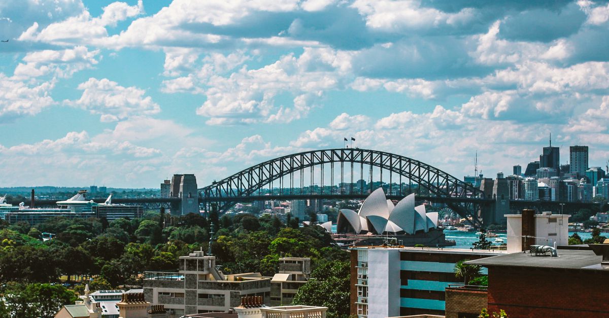 Stunning view of Sydney Harbour Bridge and Sydney Opera House on a sunny day, showcasing the vibrant cityscape.