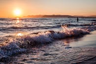 意大利拉齐奥的海面上，充满活力的日落映照出金色的倒影，构成完美的海景