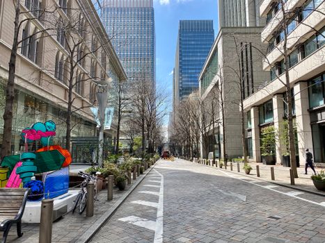 A scenic urban view of Chiyoda City, Tokyo with modern skyscrapers and public art.