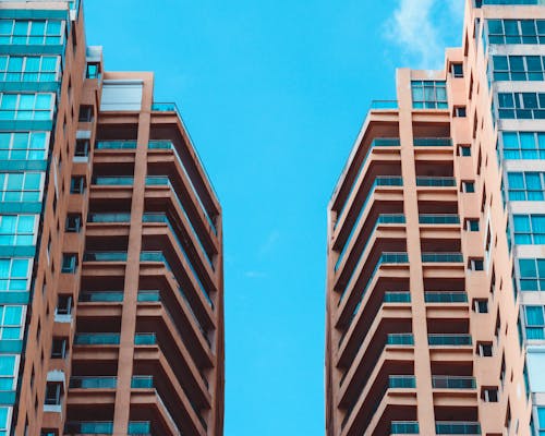 Vista De ángulo Bajo De Dos Edificios Altos Bajo Un Cielo Azul