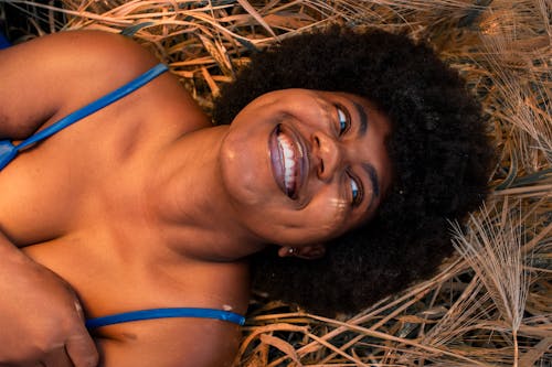 A Woman Lying on Brown Grass