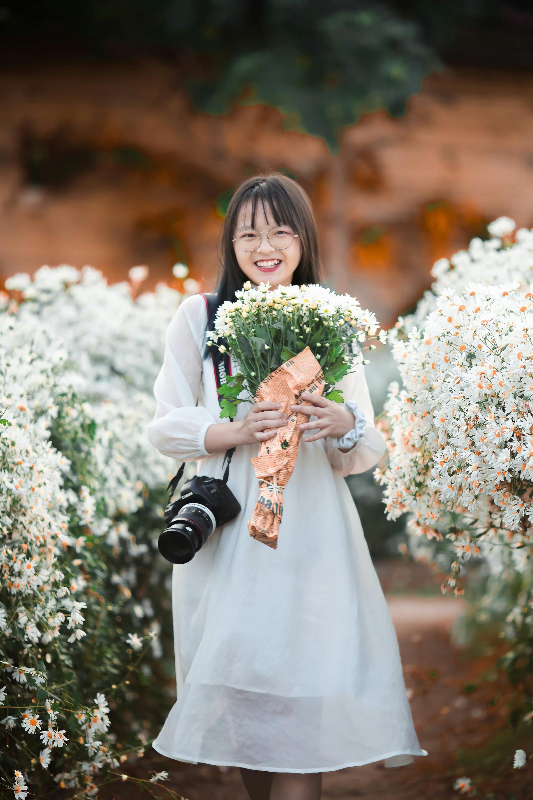 Woman in White Long Sleeve Dress Holding Bouquet of Flowers · Free