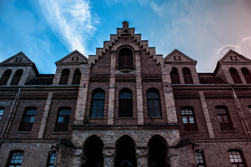 Free Low angle view of a historic brick building facade against a blue sky in Corupá, Brazil. Stock Photo