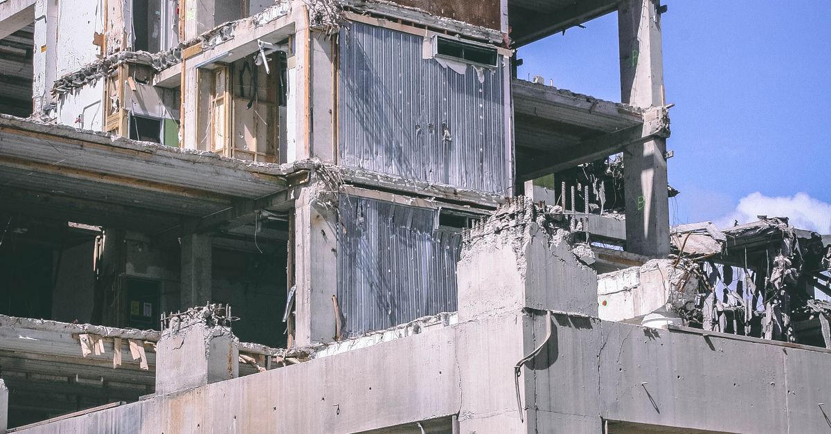 Photo by Darcy Lawrey A partially demolished building in an urban setting under a clear blue sky, captured outdoors during the day.