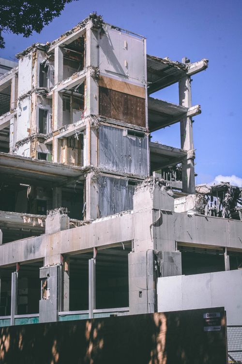 Free A partially demolished building in an urban setting under a clear blue sky, captured outdoors during the day. Stock Photo
