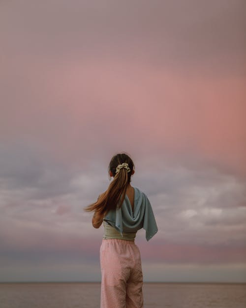 Back View of a Woman Standing Under the Sky