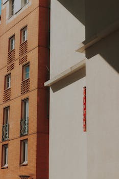 A minimalist urban scene with a modern brick and concrete building facade under daylight.
