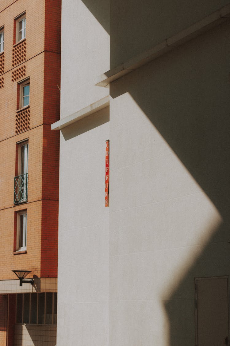 Empty White Wall Near Brick Building