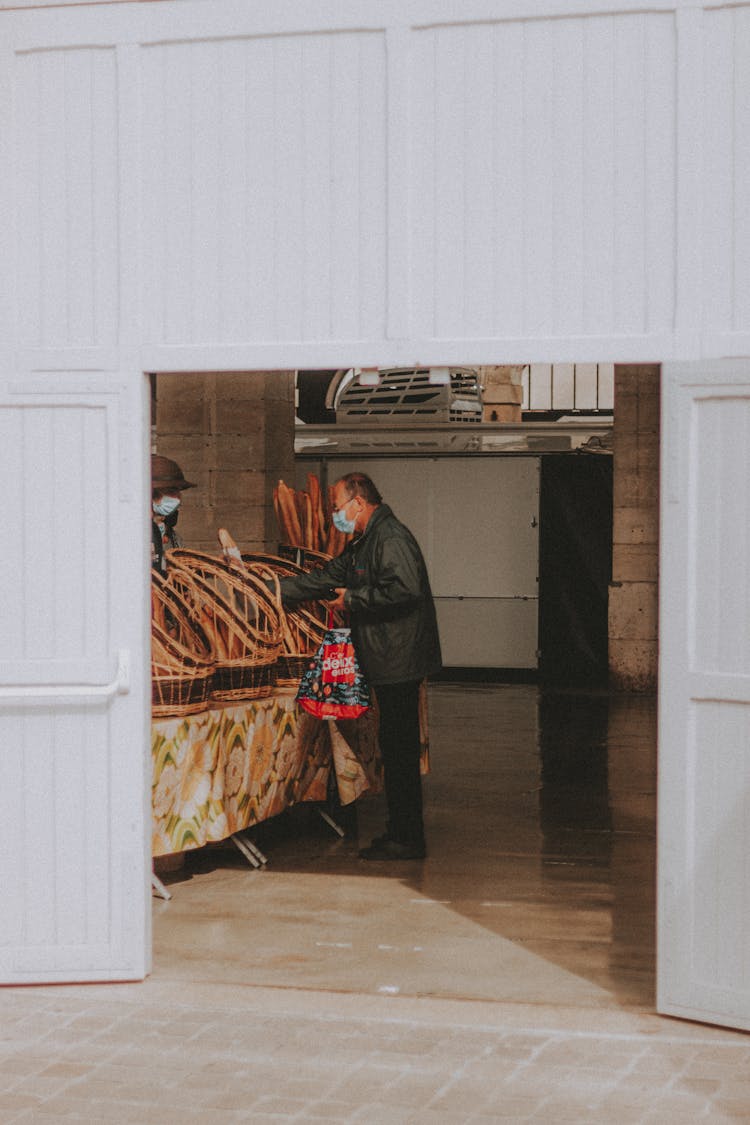 Man In Mask Choosing Goods In Market