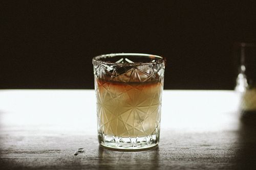 Free Elegant beverage in a clear textured glass on a wooden surface with a moody background. Stock Photo