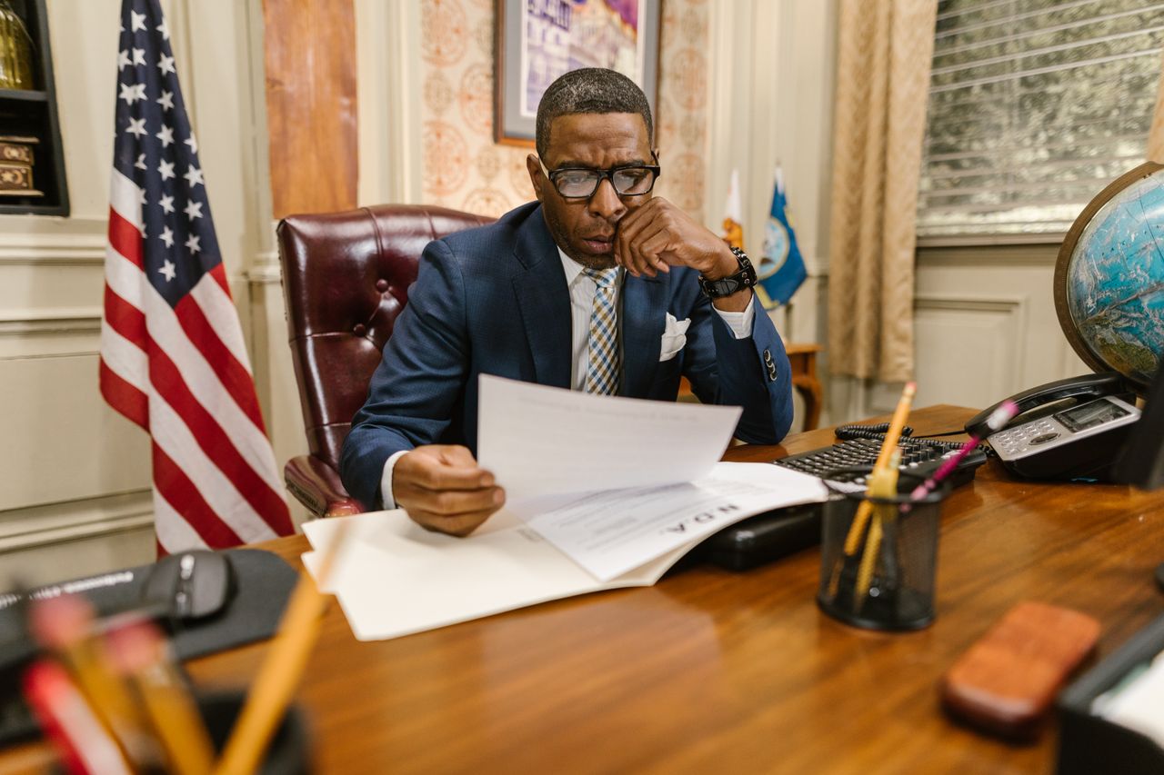 a lawyer in a suit deeply engaged in reviewing legal documents at his