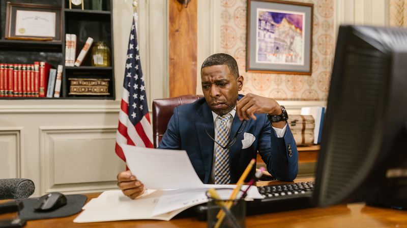 A focused lawyer reading documents in an office, symbolizing professionalism and legal expertise.