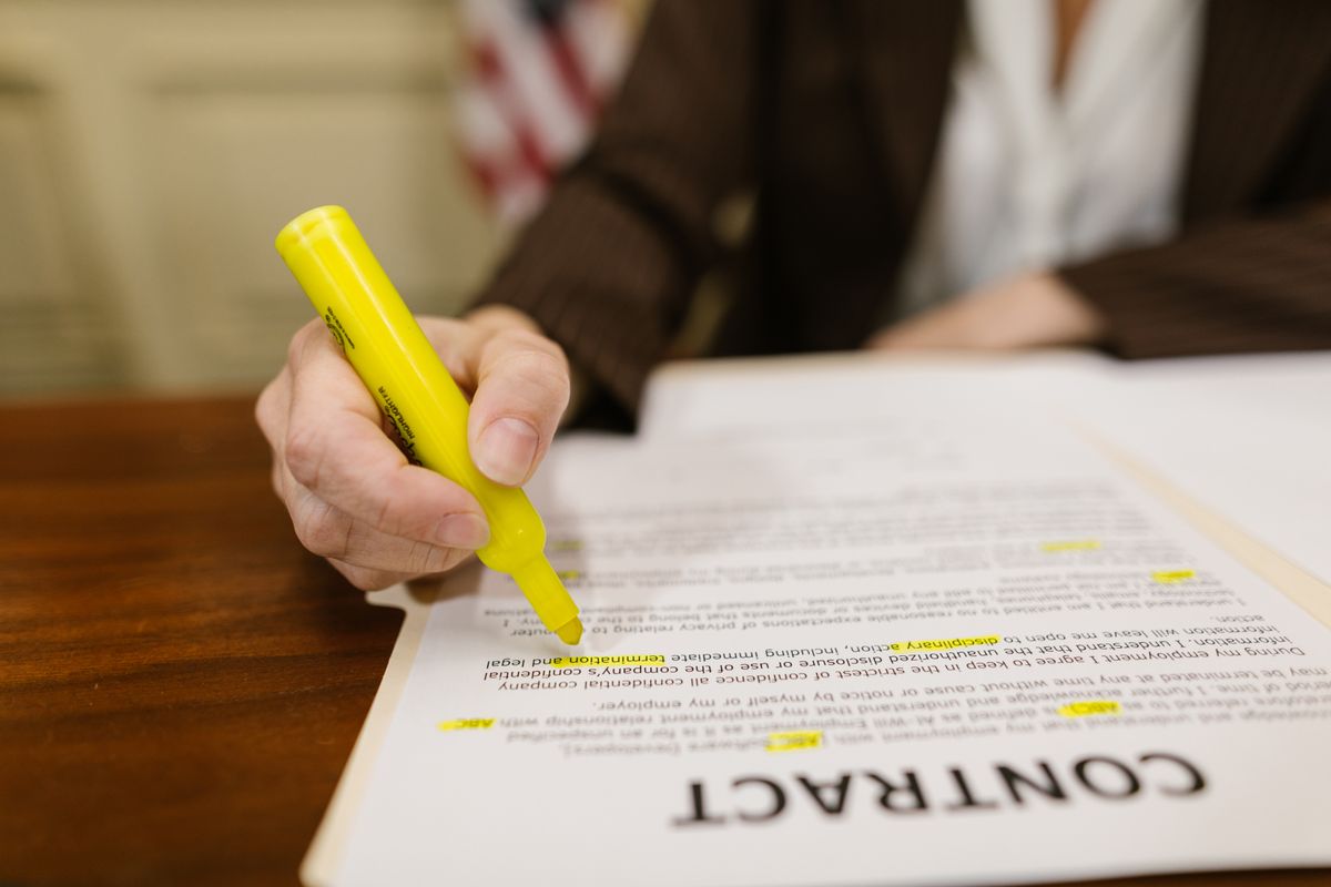 Hands turning pages of a document on a desk