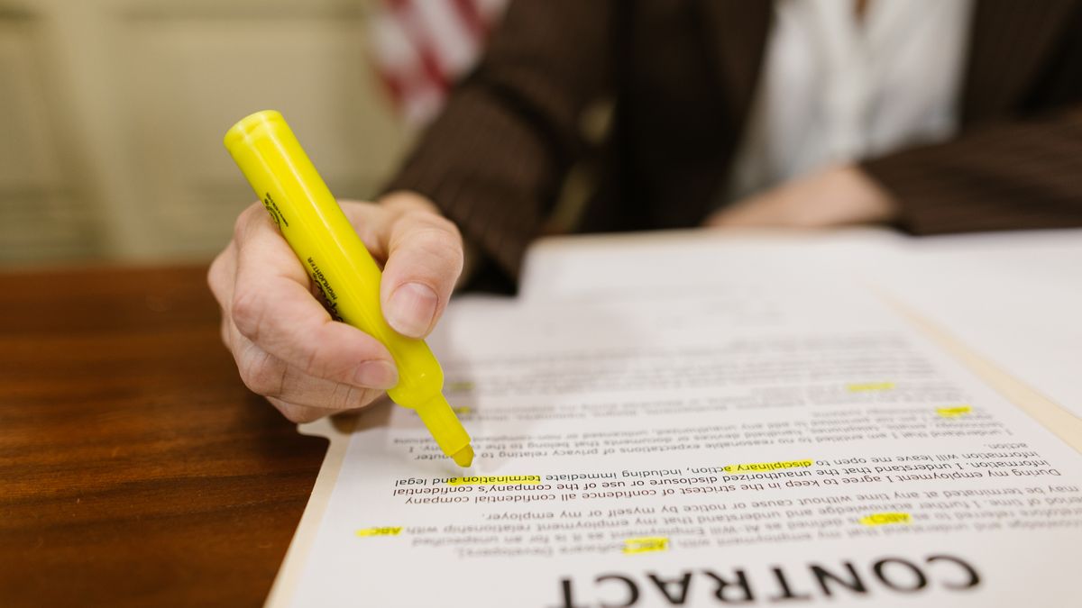 Person reviewing and signing a legal contract