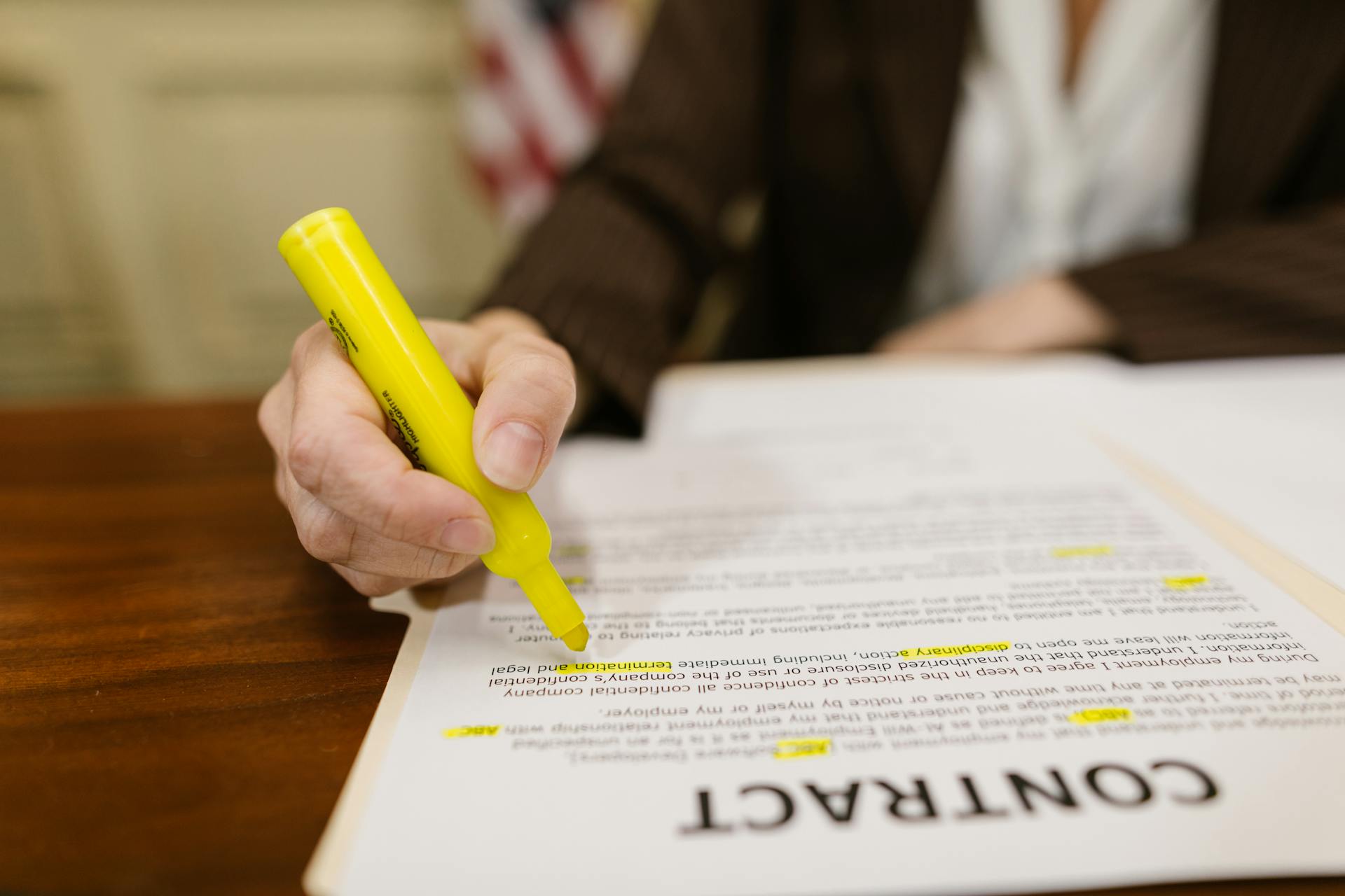 A close-up of a hand highlighting a contract, emphasizing important legal terms.