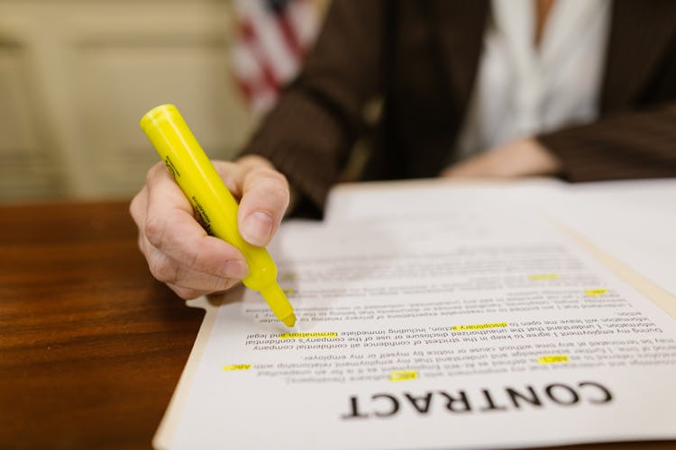 Close-Up Shot Of A Person Writing On A Contract