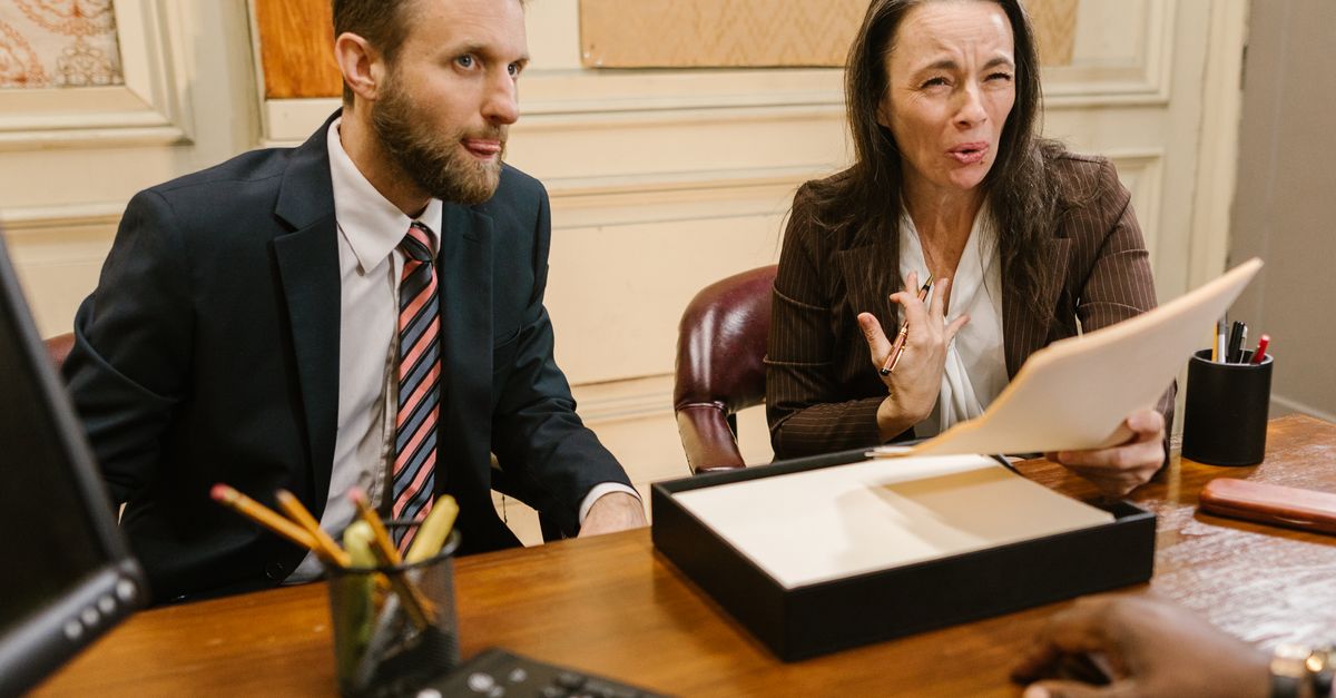 Photo by RDNE Stock project Lawyers discussing legal documents in a professional office setting.
