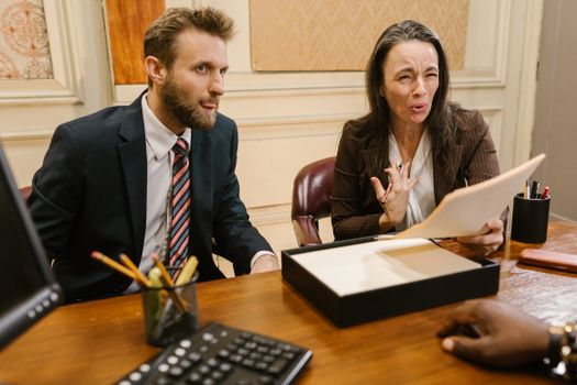Lawyers discussing legal documents in a professional office setting