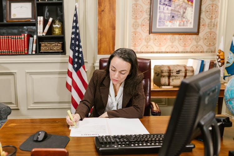 A Female Lawyer Writing On Documents