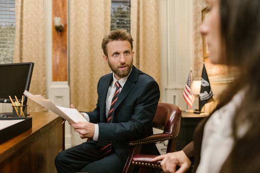 Businessman in suit discussing legal documents in office environment.